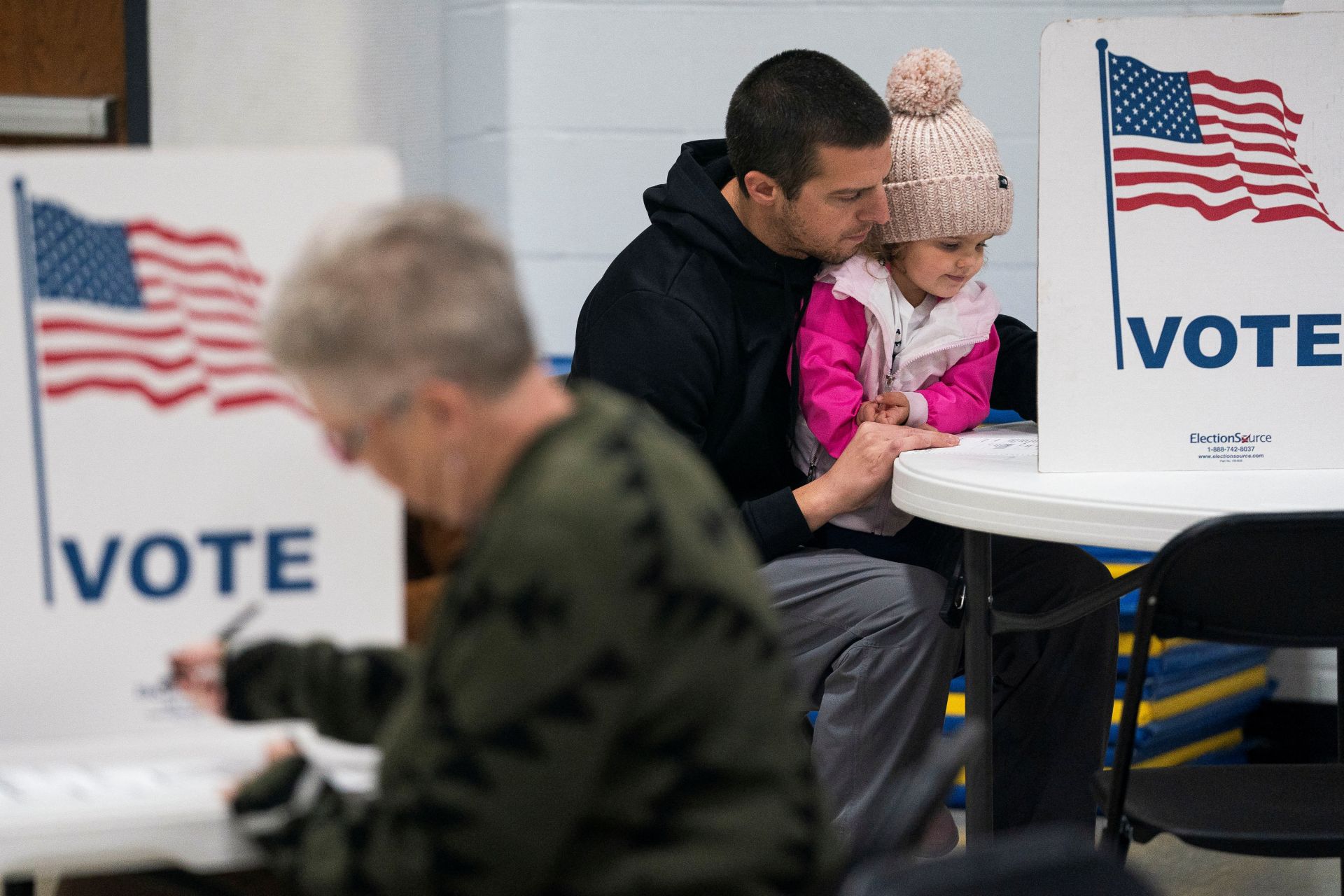 Dustin Ritchie, de 34 años, vota con su hija en las elecciones presidenciales de Estados Unidos el día de las elecciones en el lugar de votación de la Asamblea Central de Dios, Wisconsin