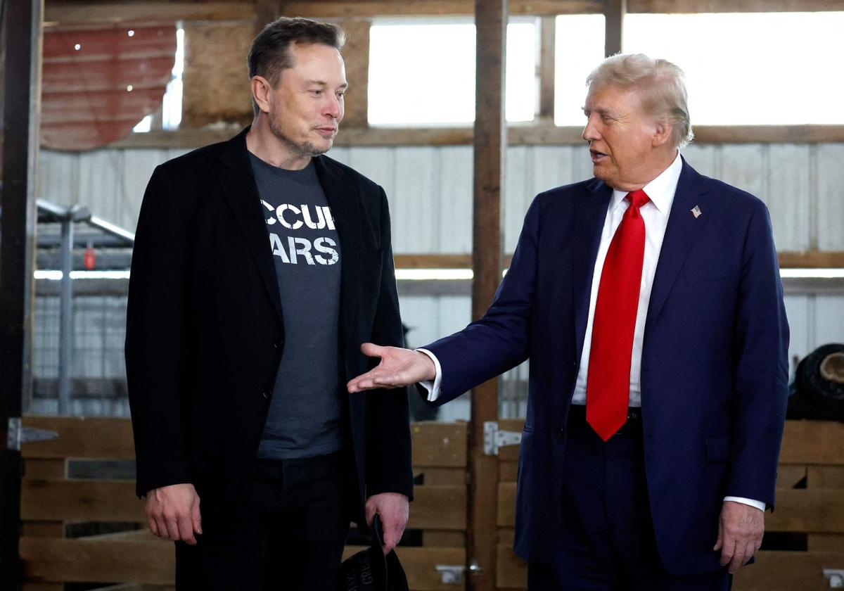 Donald Trump le tiende la mano a Elon Musk.