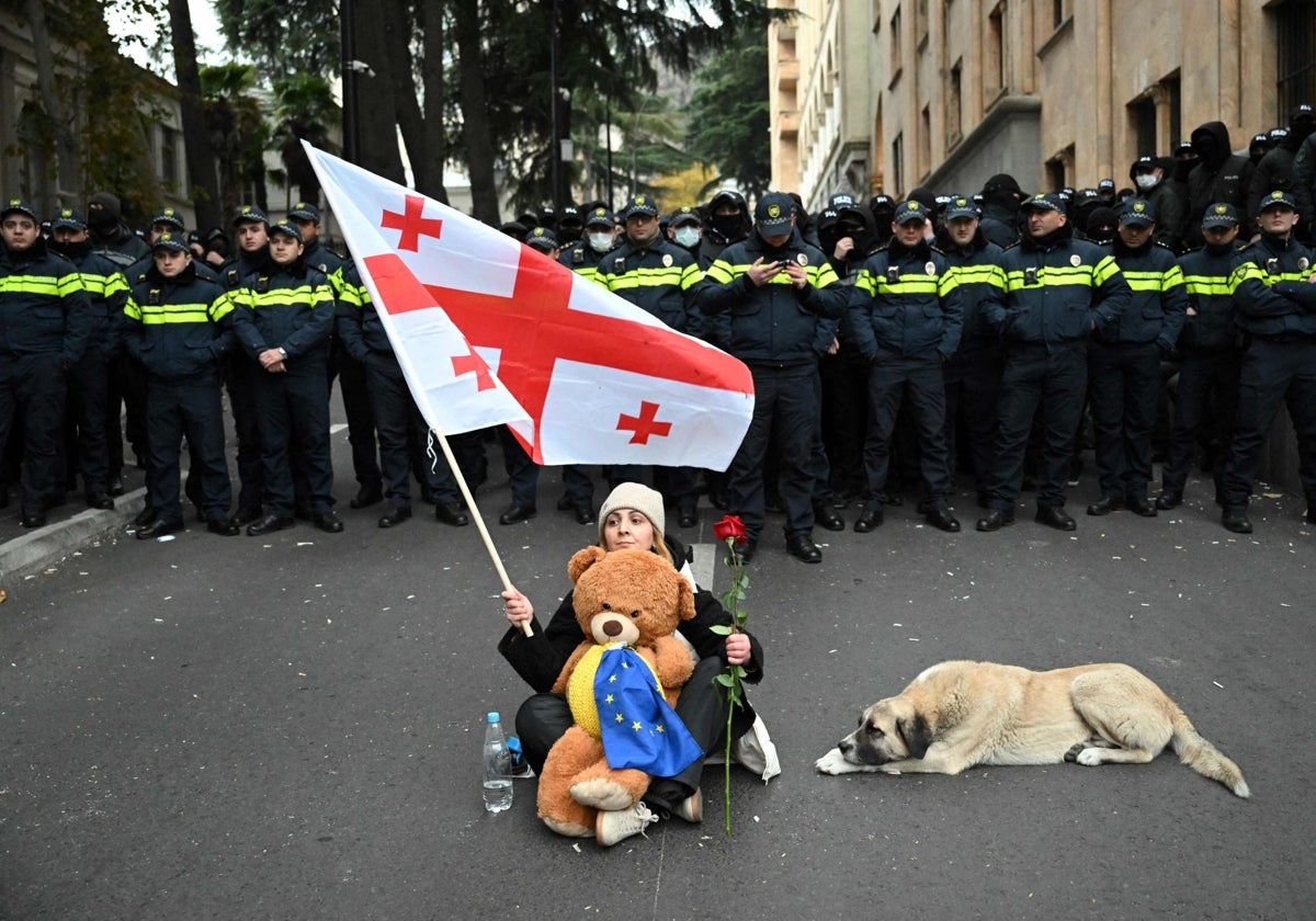 Una mujer protesta con una rosa y una bandera georgiana tras  las elecciones parlamentarias en Georgia