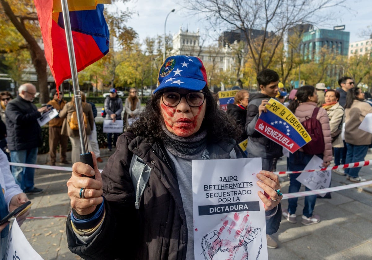 Una mujer sujeta un cartel de protesta durante una manifestación de venezolanos en Madrid, frente a la comisión del Parlamento Europeo