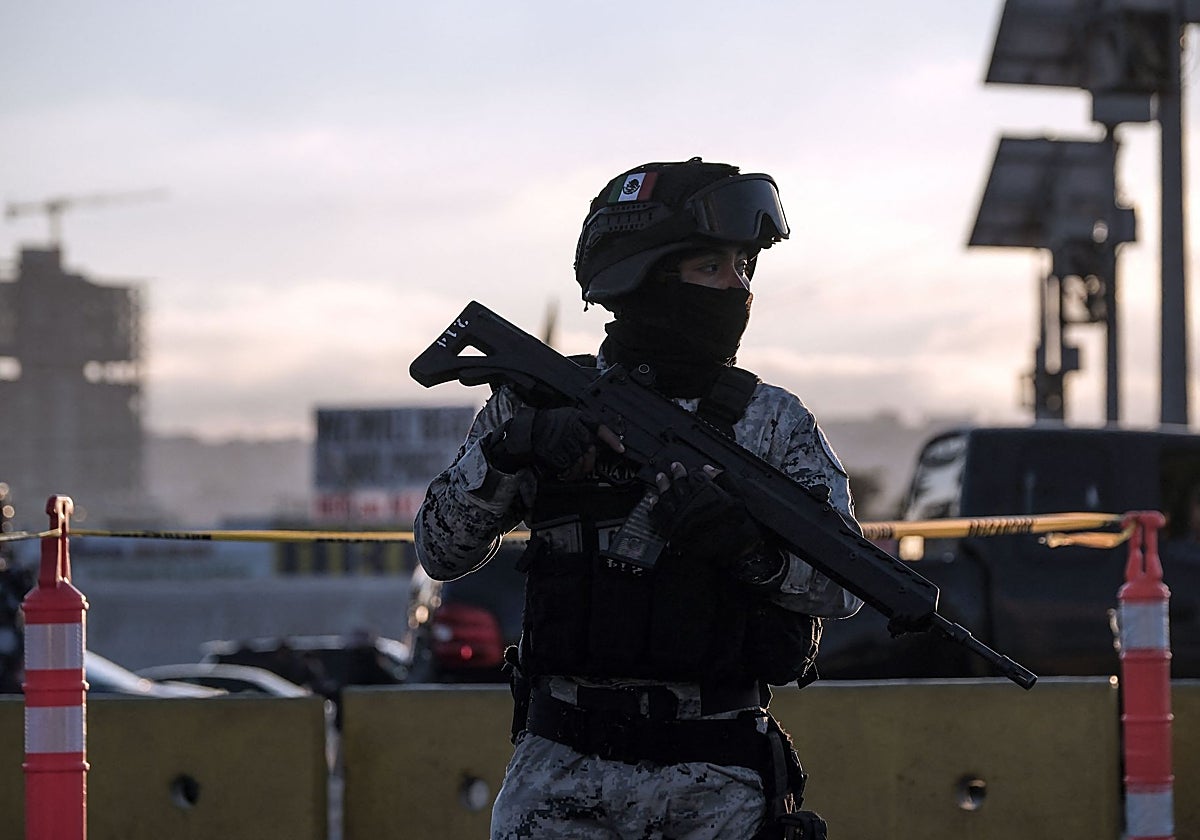 Un oficial de la Guardia Nacional Mexicana revisa vehículos antes de que crucen a Estados Unidos