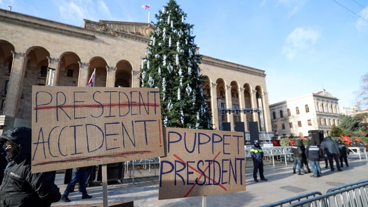 Police officers stand guard outside the Parliament building during a demonstration by anti-government activists