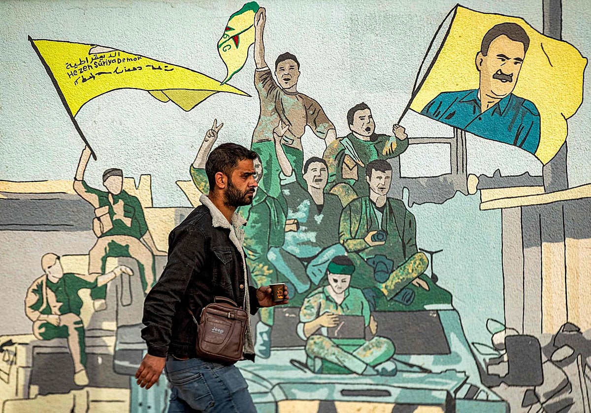 Un hombre pasa junto a un mural