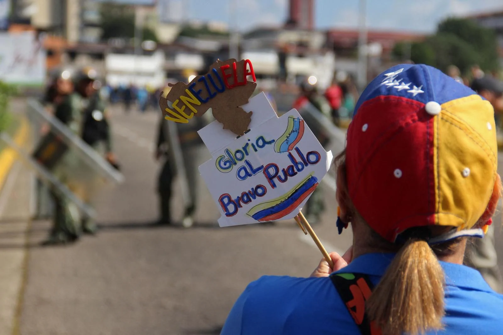 Un manifestante se encuentra frente a las fuerzas de seguridad que hacen guardia durante la protesta convocada por la oposición