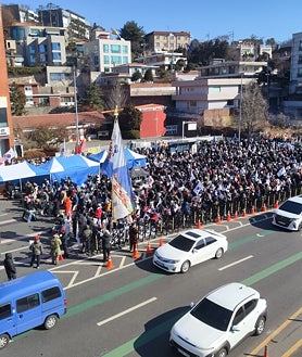 Imagen secundaria 2 - Una pancarta que llama a «disolver la Asamblea Nacional», un autobús bloquea la residencia del presidente y partidarios de Yoon se manifiestan en los alrededores del edificio
