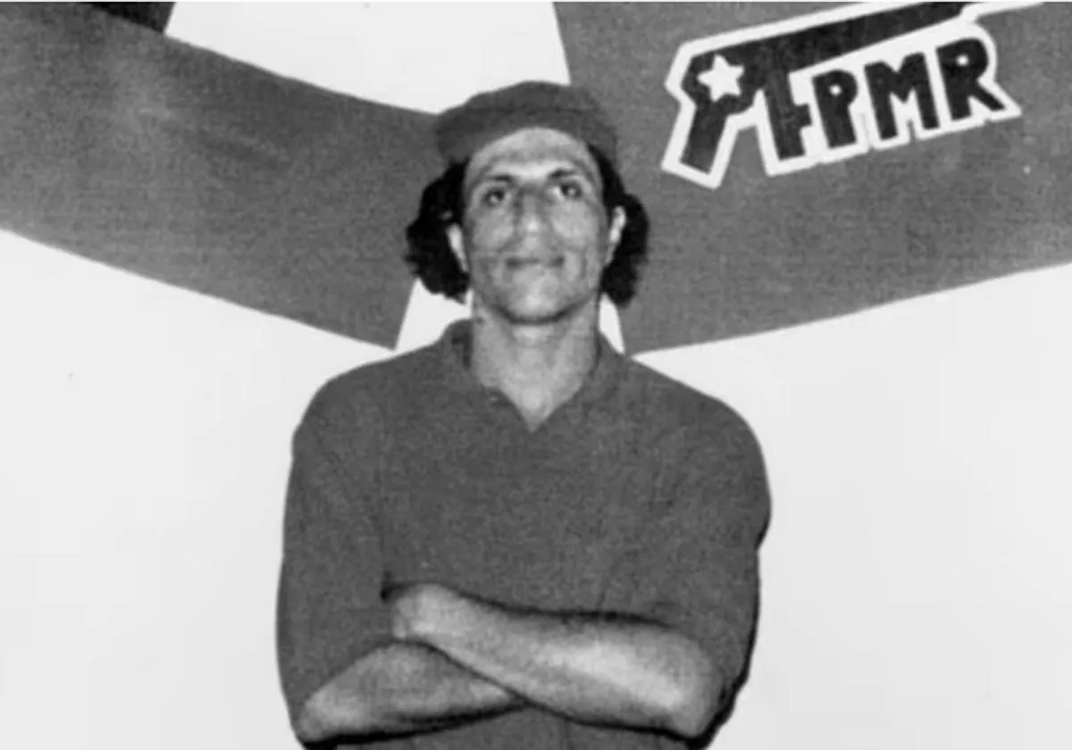 Pablo Muñoz Hoffman en una imagen de los años 1990, frente al logo del Frente Patriótico Manuel Rodríguez (FPMR)