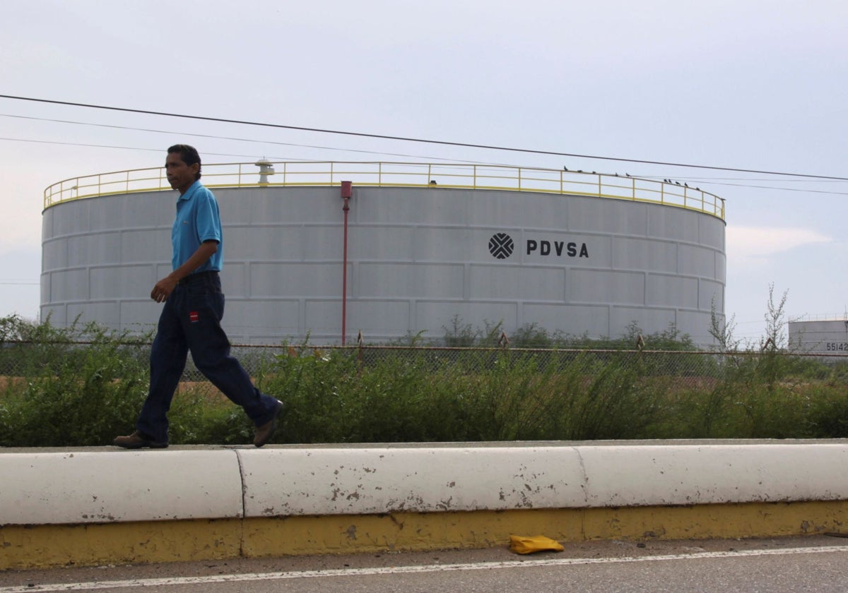 Foto de archivo: Un hombre pasa junto a un tanque con el logo de la petrolera venezolana PDVSA