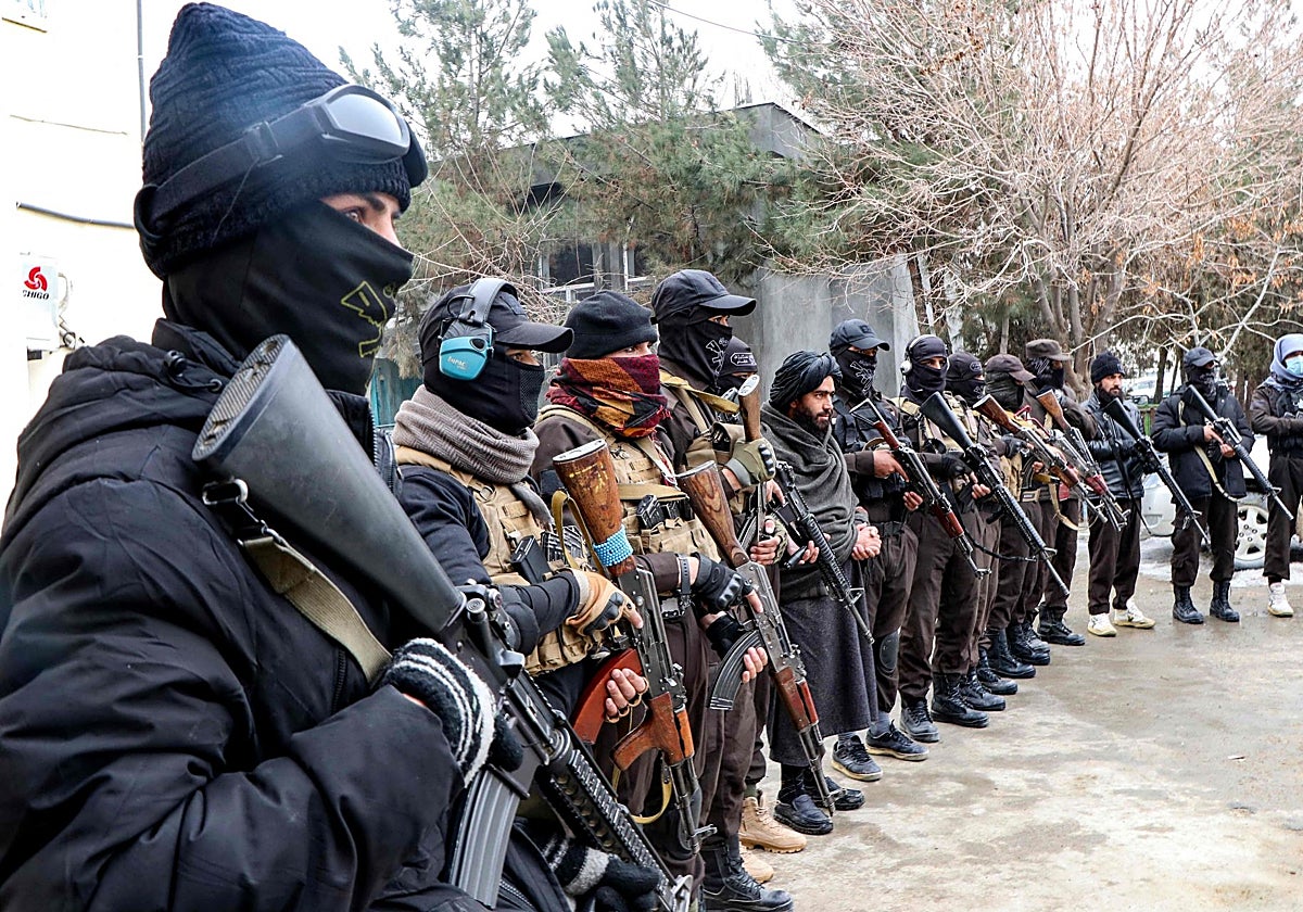 El personal de seguridad talibán hace guardia mientras exhibe armas confiscadas en la sede de la policía en Ghazni