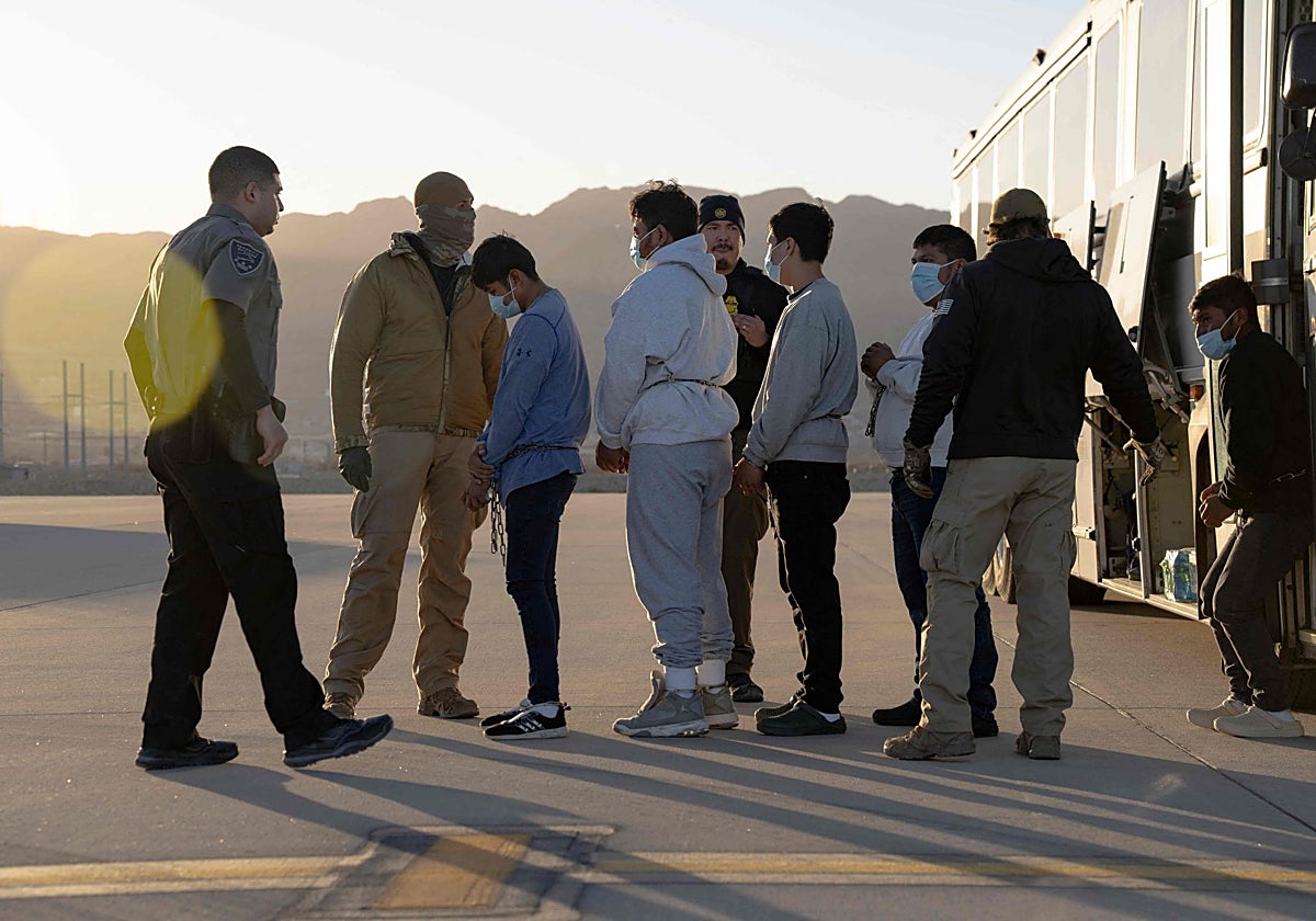 Agentes de Aduanas y Protección Fronteriza de EE.UU. guian a inmigrantes indocumentados para abordar un vuelo de deportación en Texas