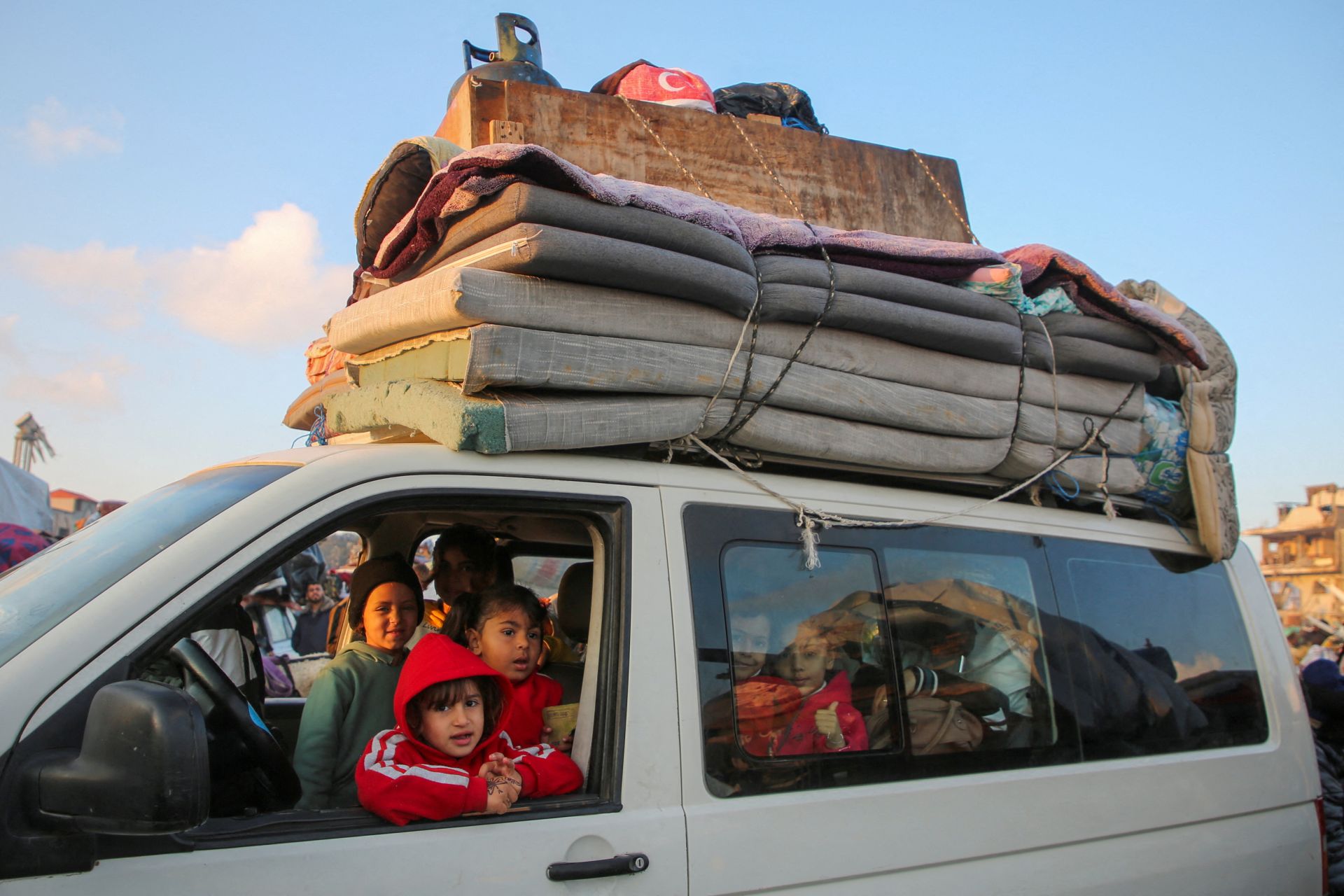 Palestinos esperan que se les permita regresar a sus hogares en el norte de Gaza con un vehículo a través de la carretera de Salahudeen después de haber sido desplazados hacia el sur por orden de Israel durante la guerra, en medio de un alto el fuego entre Israel y Hamás, en el centro de la Franja de Gaza, el 27 de enero de 2025.