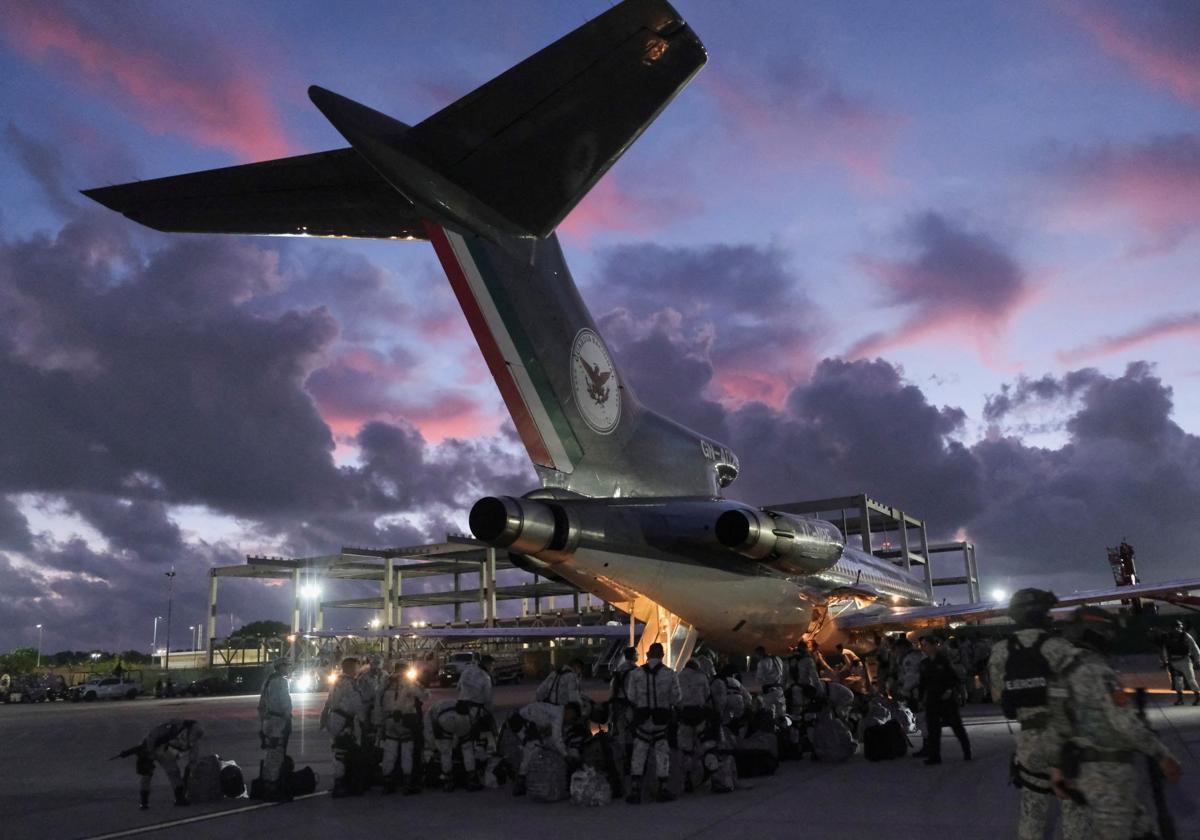 Miembros de la Guardia Nacional de México se preparan para abordar un avión con destino a la frontera