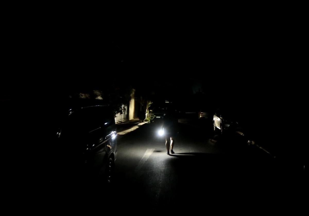 Una persona camina con una linterna este martes, en Santiago (Chile)