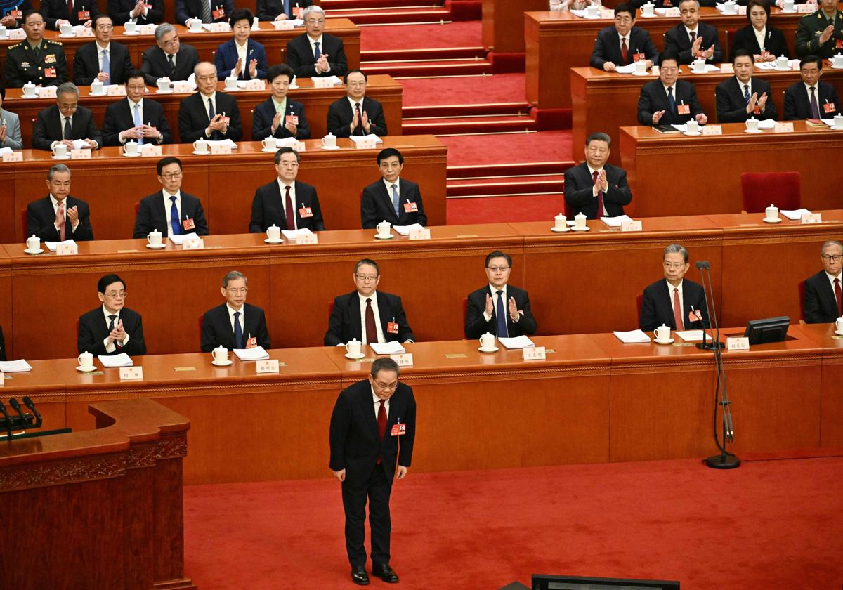 Xi Jinping (primero por la derecha de la imagen en la segunda fila) aplaude al primer ministro Li Qiang en la Asamblea Nacional Popular