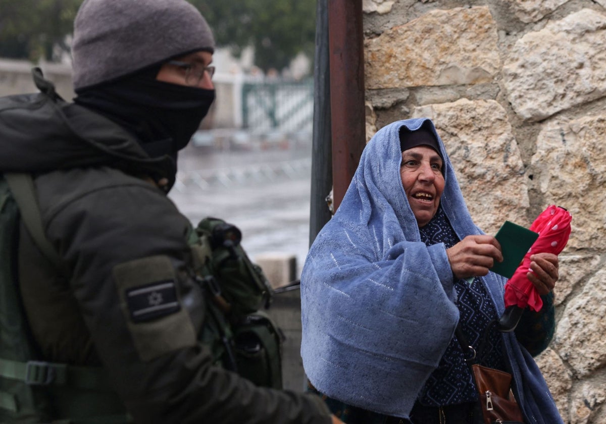 Una mujer palestina muestra su documentación a las autoridades israelíes para acceder a Jerusalén