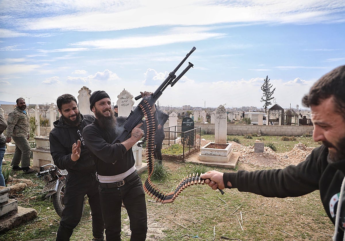 Un hombre armado dispara al aire durante el funeral de un miembro de las fuerzas de seguridad sirias muerto en un ataque de grupos leales al derrocado presidente Al Assad