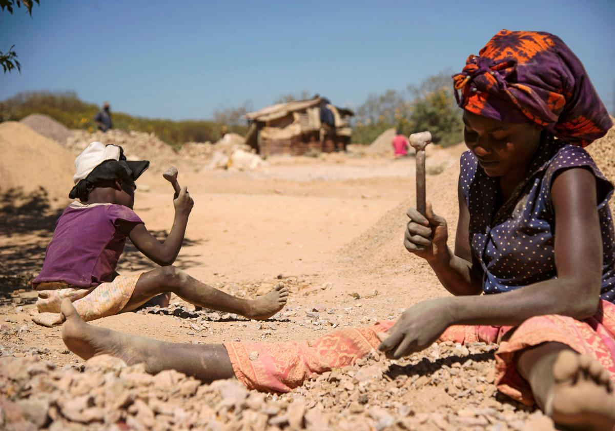 Un niño y una mujer rompen rocas de una mina de cobalto en Lubumbashi en una imagen de archivo