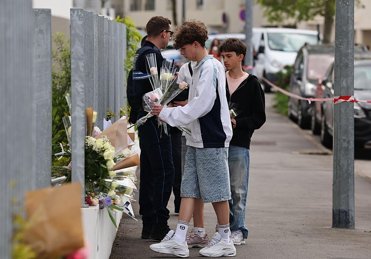 Estudiantes llevan flores a la escuela tras el ataque.