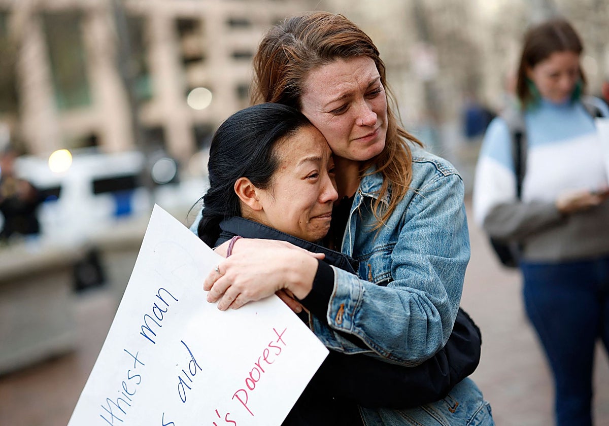 Dos mujeres lloran durante una manifestación de apoyo al personal de la USAID