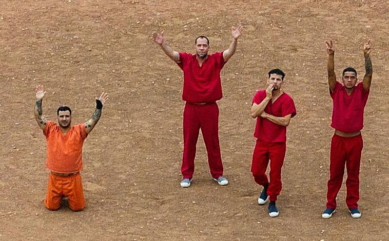 Imagen principal - Algunos de los presos hacen señales al dron de Reuters para pedir ayuda