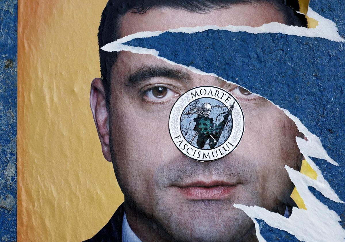 Cartel del favorito, George Simion, con una pegatina contra el fascismo