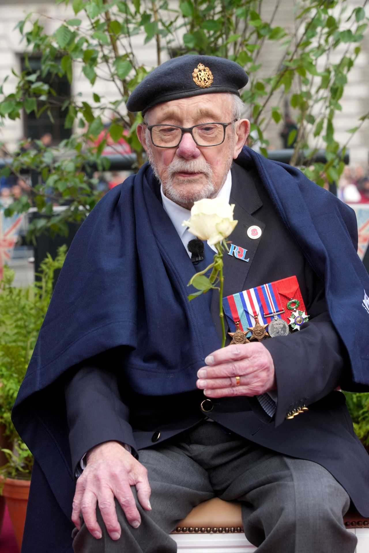 El veterano de la Segunda Guerra Mundial Alan Kennett recibe una flor cerca de Parliament Square