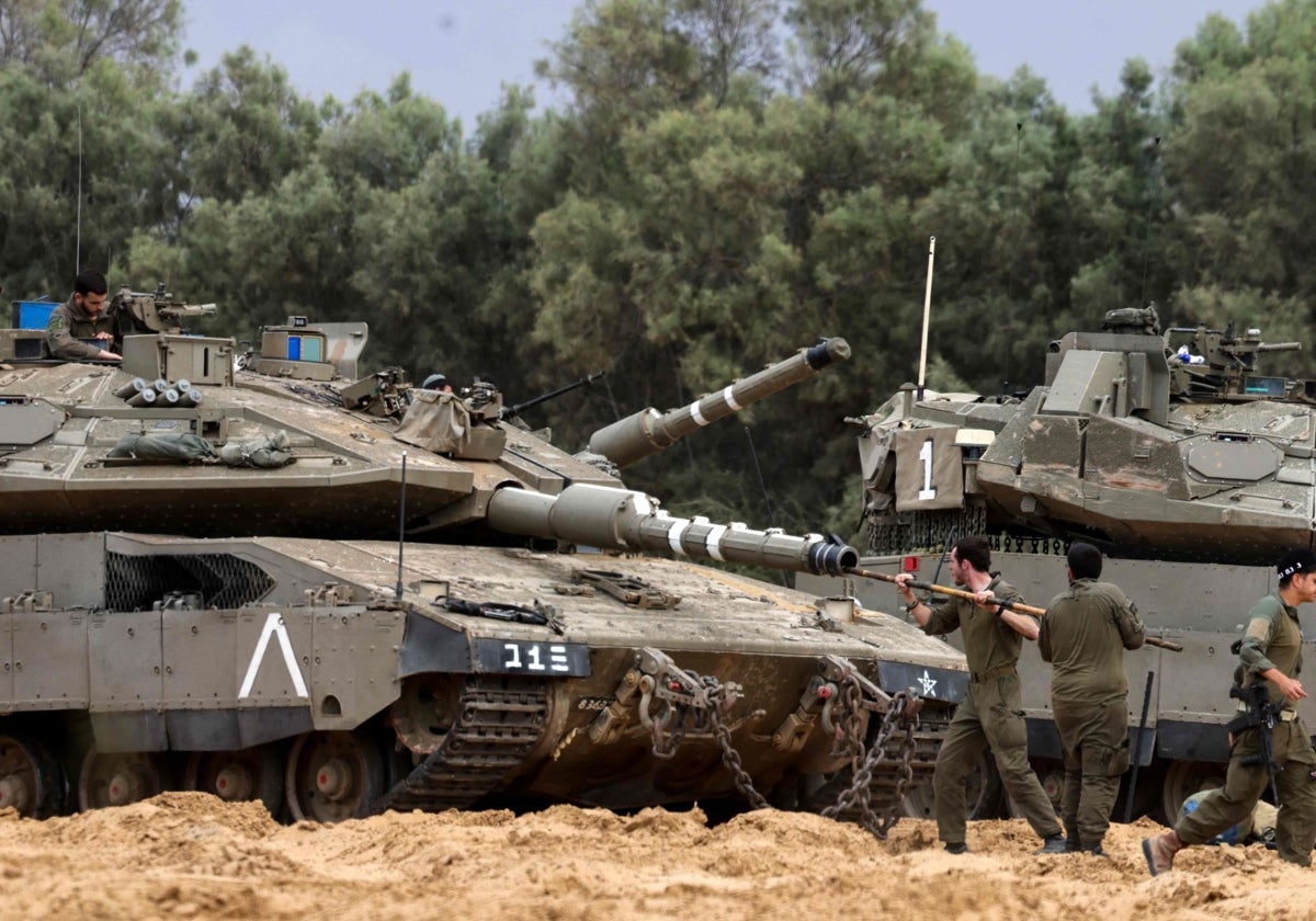 Soldados israelíes limpian el cañón de un tanque en una posición cercana a la frontera de Israel con Gaza