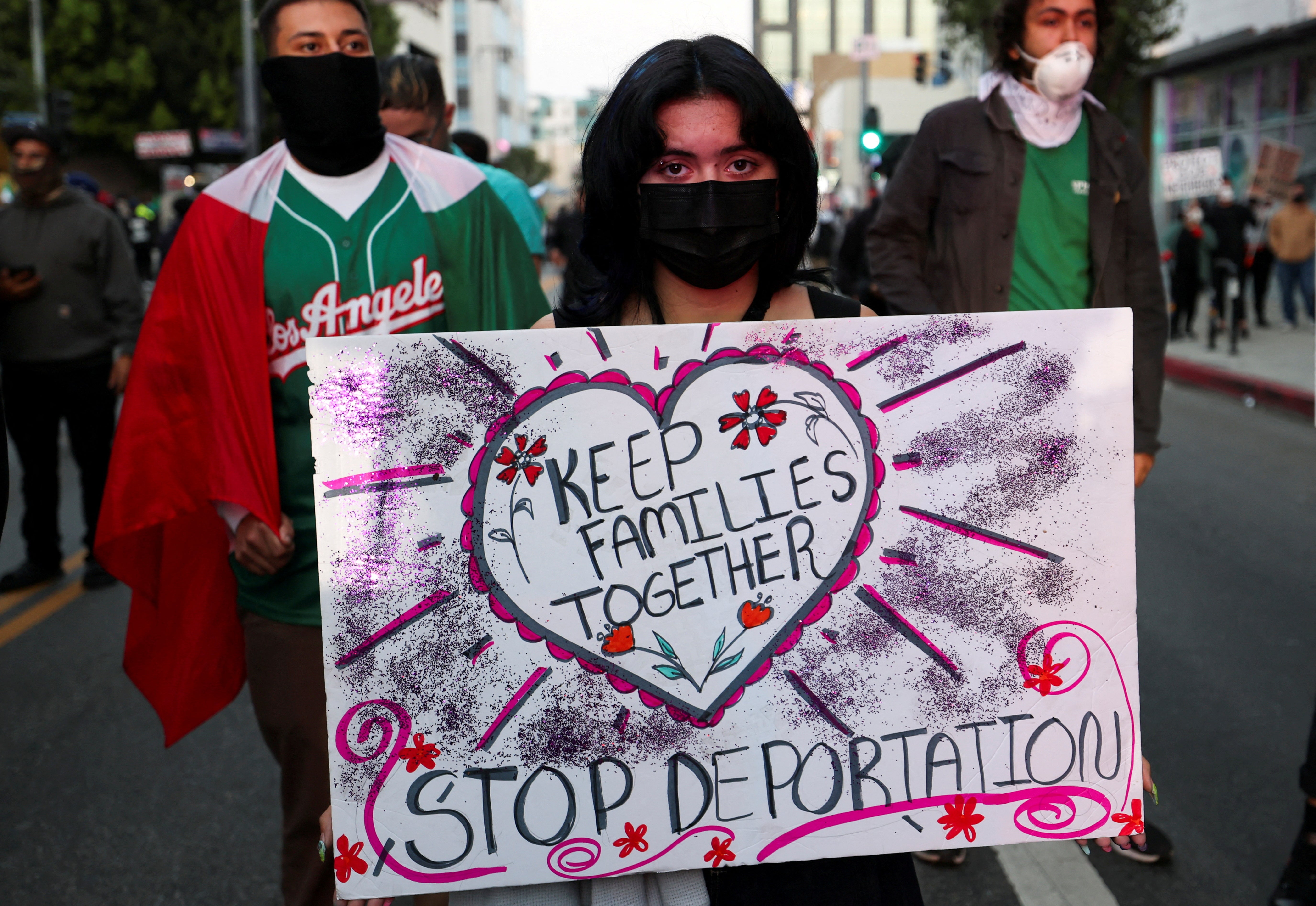 Una mujer pide en una pancarta que se mantenga a las familias unidas y se ponga fin a las deportaciones