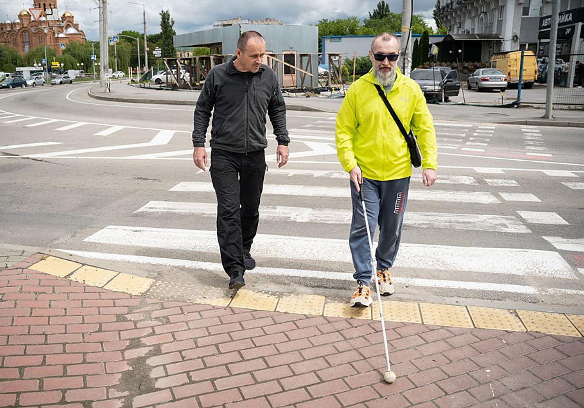 Vasil enseñando a Andriy a orientarse con el bastón