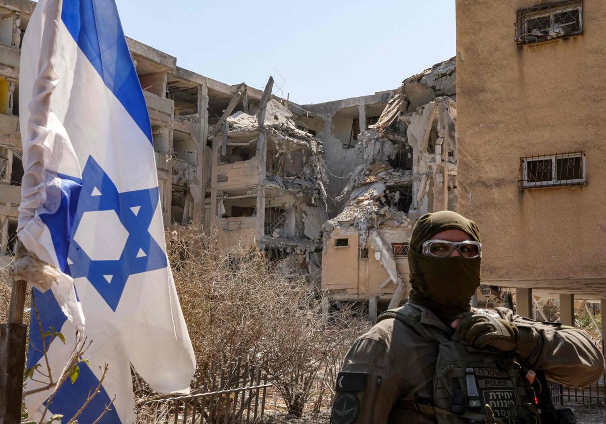 Un policía israelí monta guardia ante un edificio alcanzado por un misil iraní en el centro de Israel
