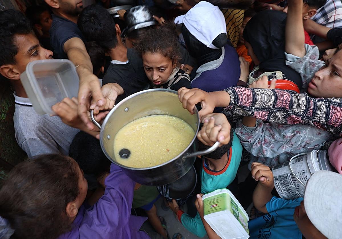 Un grupo de palestinos hacen cola para obtener comida en Nuseirat, en el centro de Gaza