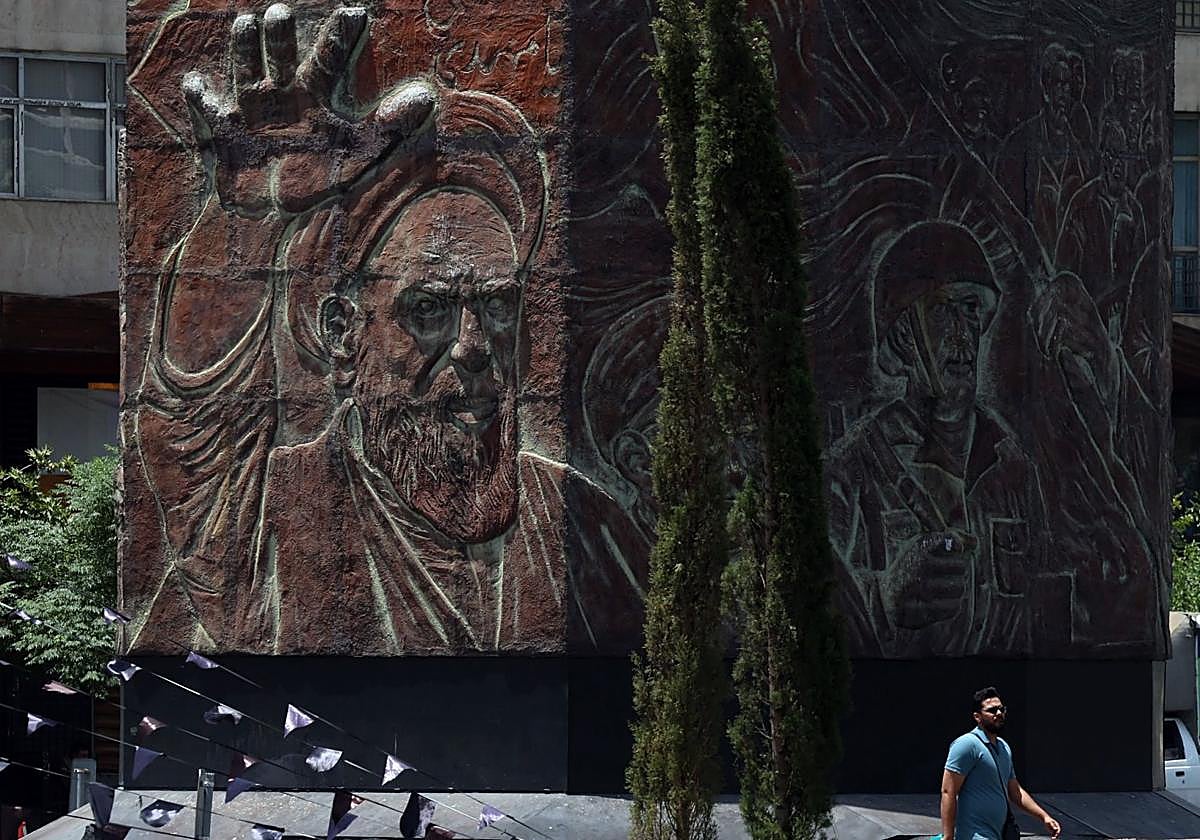 Un hombre pasa junto a una estatua del difunto líder supremo Ayatolá Ruholá Jomeini en Teherán.