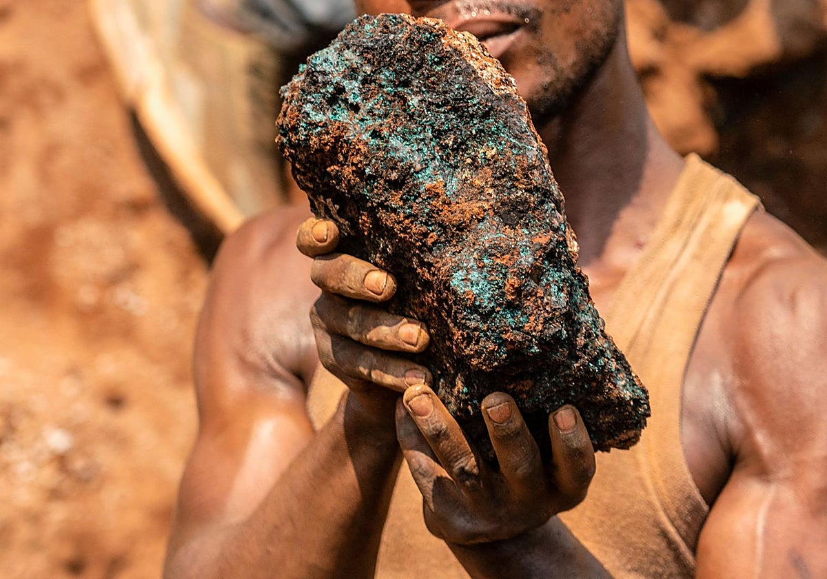 Un minero artesanal sostiene una piedra de cobalto en la mina artesanal de Shabara, cerca de Kolwezi, en la RDC