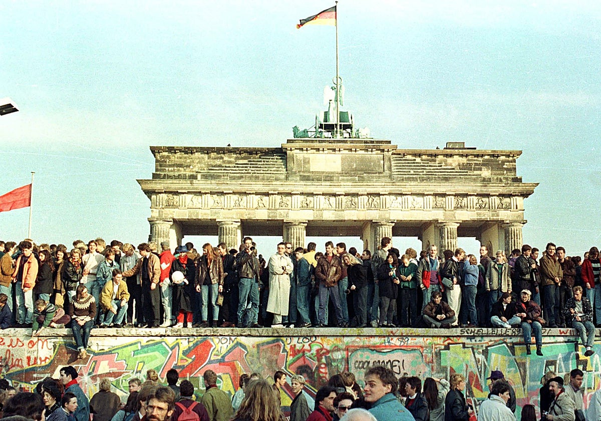 Los berlineses se suben al Muro de la vergüenza que, desde hacía 28 años, dividía su ciudad en dos y simbolizaba el Telón de Acero entre la Europa democrática y las dictaduras comunistas