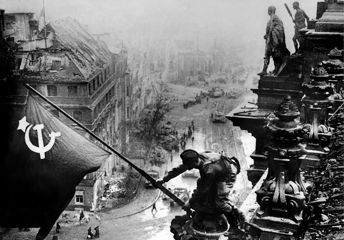 Entre las ruinas de Berlín, las tropas soviéticas izan la bandera de la hoz y el martillo en señal de victoria en la azotea del Reichstag, la sede del Parlamento alemán