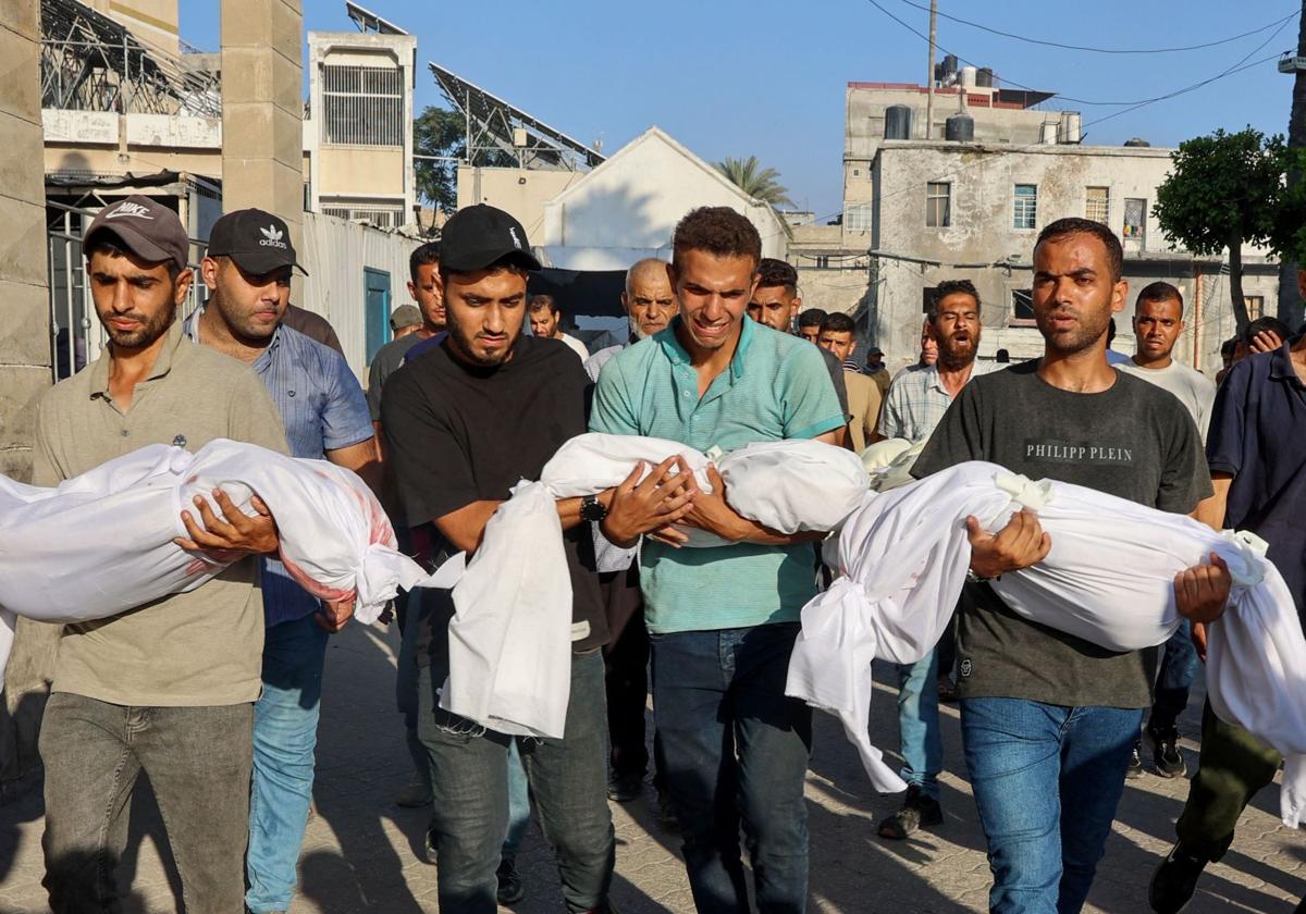 Hombres palestinos transportan los cadáveres de los muertos en un ataque israelí en Gaza