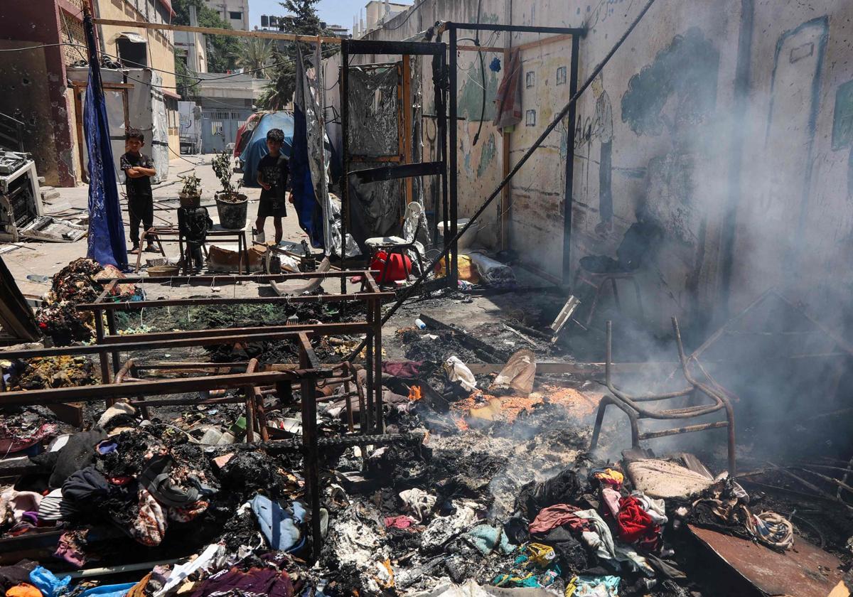 Unos niños observan los escombros humeantes de la escuela Mustafa Hafez, en Gaza.