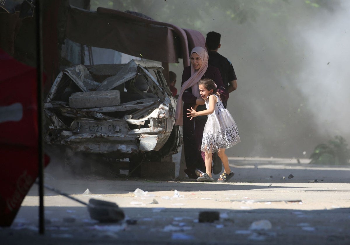 Una niña con su madre gazatí escapan de los ataques israelíes