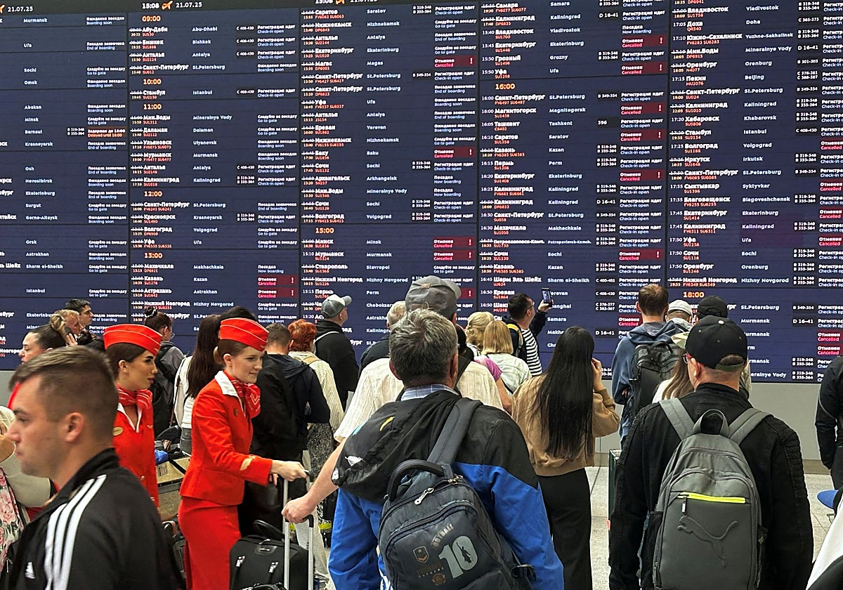 La gente se reúne en el panel de información después de que muchos vuelos se cancelaran debido a los ataques ucranianos, en el aeropuerto internacional  de Moscú