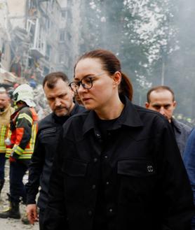 Imagen secundaria 2 - En la primera imagen, un coche en llamas tras el ataque ruso sobre Kiev. Una mujer abraza a otra mientras espera a que su hijo sea rescatado de entre los escombros, en la segunda foto. En la tercera imagen: la primera ministra ucraniana, Yulia Svyrydenko, y el ministro del Interior, Ihor Klymenko, caminan por los escombros que ha dejado el ataque ruso