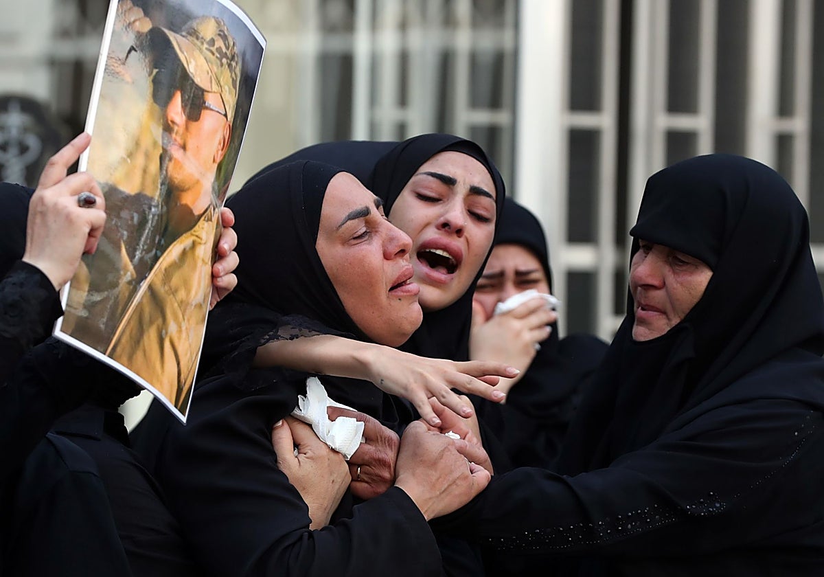 Familiares consuelan a una madre que llora la muerte de uno de los seis soldados en un atentado el viernes