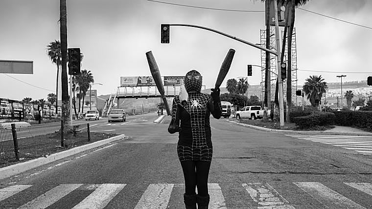 Claudia trabaja como artista callejera en uno de los semáforos de la ciudad, buscando ingresos en el espacio público. Durante años, Tijuana ha sido refugio y punto de paso para inmigrantes y deportados que no lograron alcanzar su sueño americano