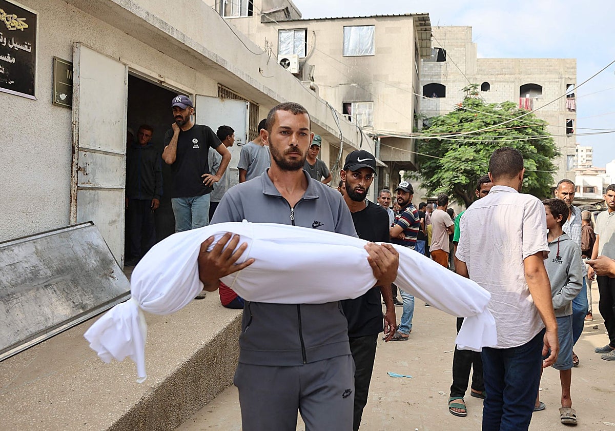 Un palestino carga el cuerpo de un niño mueto en un ataque israelí en Ciudad de Gaza