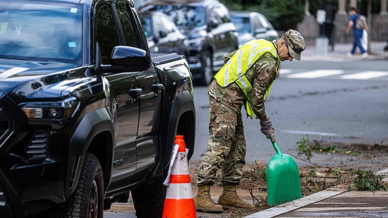 Un miembro de la Guardia Nacional de EE. UU. limpia escombros de la carretera