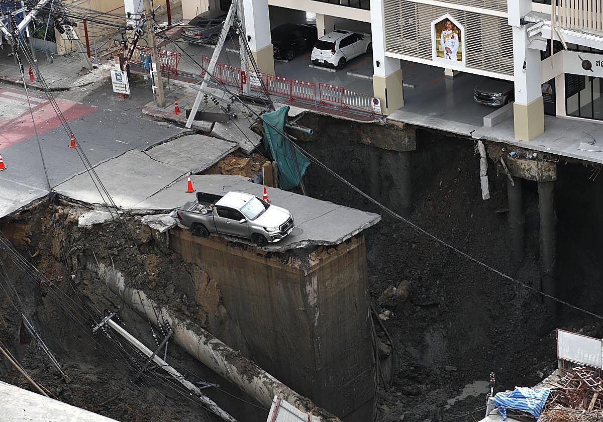 Un coche, a punto de caer en el socavón.
