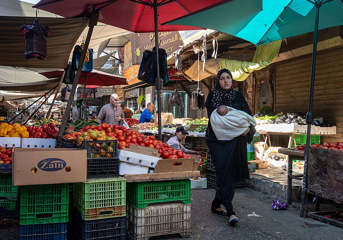Una mujer camina por el mercado del campamento de Baqa'a en Jordania