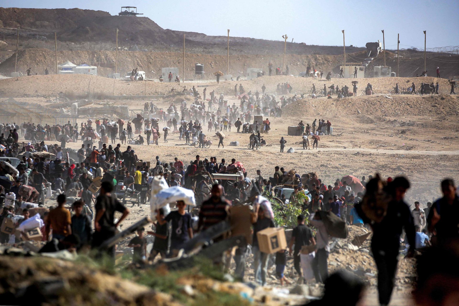 Las personas caminan con paquetes de ayuda humanitaria que recibieron de un centro de distribución gestionado por la Fundación Humanitaria de Gaza (GHF), respaldada por Estados Unidos e Israel.