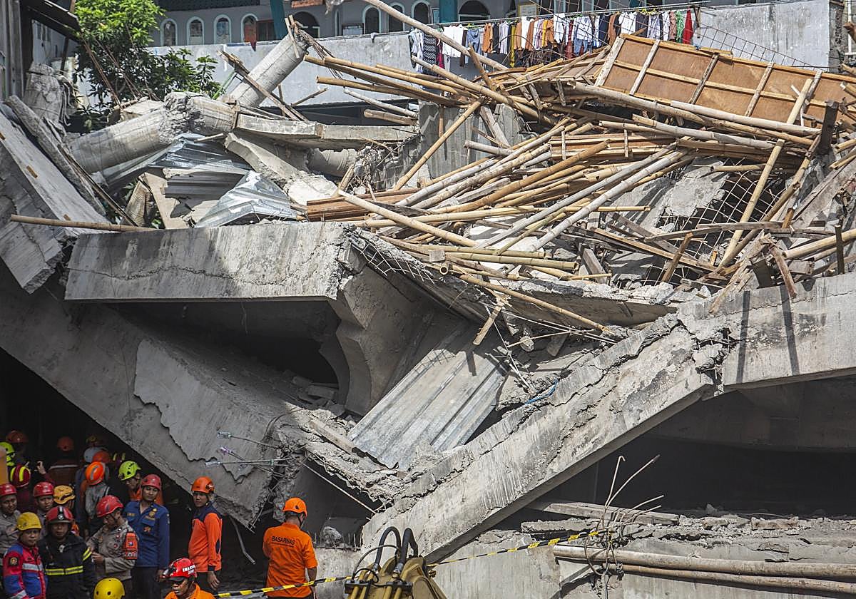 Los equipos de rescate trabajan frenéticamente para encontrar a las 90 personas atrapadas en el derrumbe del colegio en Indonesia