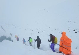 Tursitas caminan por el Everest en plena nieve.