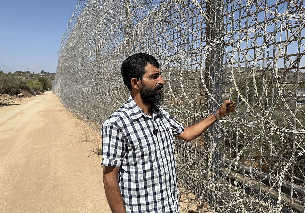 Dafi Husein, vecino de Sinjil, frente a la barrera de espino que ha plantado Israel en Sinjil (Cisjordania)