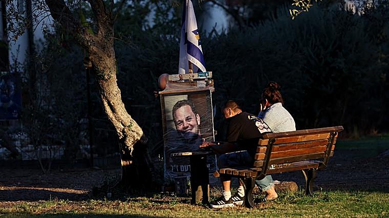 Familiares lloran delante del retrato de uno de los asesinados por Hamás en el kibbutz de Kfar Aza